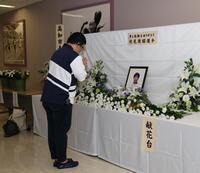 伏見俊昭さんの献花台に手を合わせるファン（撮影・中田匡峻）