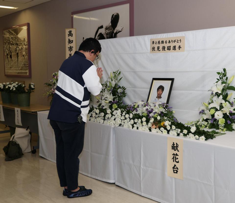 伏見俊昭さんの献花台に手を合わせるファン（撮影・中田匡峻）