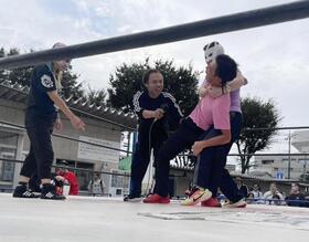 コブラツイストをかけられる青木治親と阿部剛士（左）