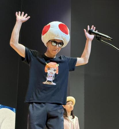 きのこのかぶり物を被って登場した新田雄史