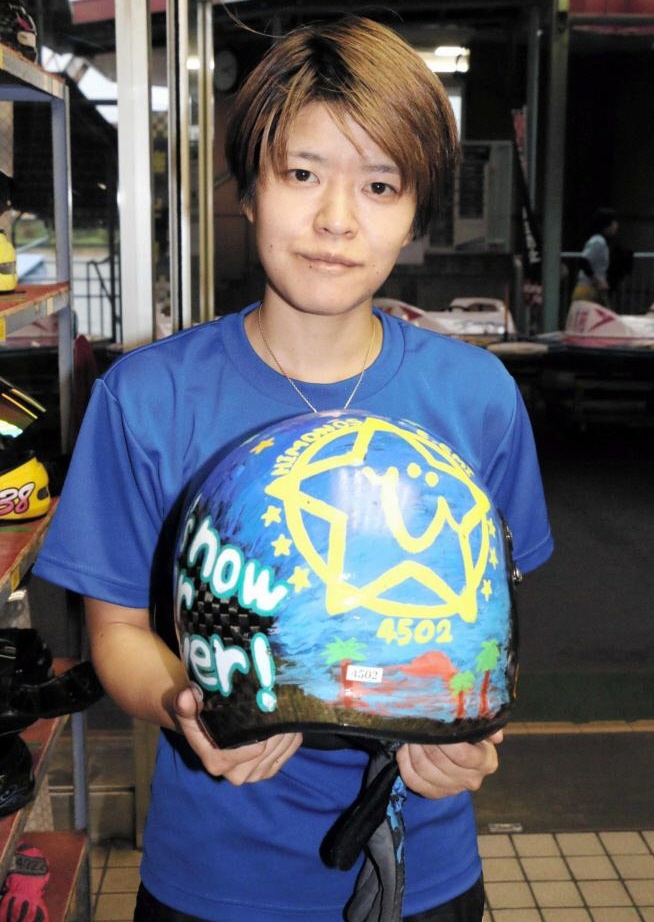 　手作りのデザインが描かれたヘルメットを手にする遠藤エミ