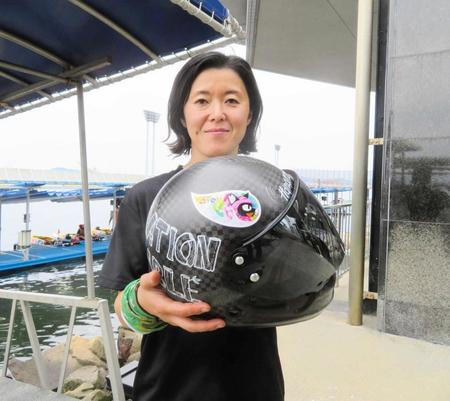 　エイベットのシールを貼ったヘルメットを見せる池田明美