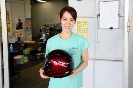 　左右非対称のヘルメットを持ち笑顔の山本梨菜