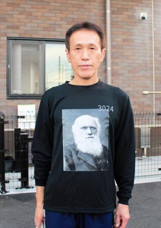 ダーウィンの肖像と名言を記したＴシャツを着用している西島義則