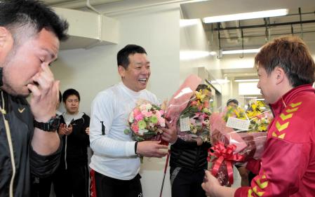 　レース後、竹内雄作（右）ら後輩選手から花束を受け取る山田裕仁。左は目頭を押さえる吉田敏洋