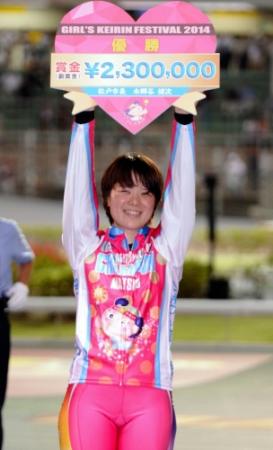 　表彰式で優勝賞金ボードを誇らしげに掲げる小林優香