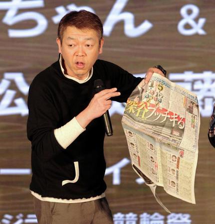 本紙紙面を手にトークショーに出演した玉ちゃん＝小倉競輪場（撮影・保田叔久）