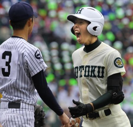 　２回、先制の中前タイムリーを放ち一塁上で雄たけびを上げる報徳・山口（右）