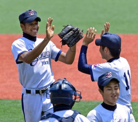 　厚木北に勝利し、ナインとハイタッチをかわす横浜創学館・ウィットロウ（左）＝撮影・村中拓久