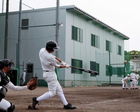 　屋内練習場（奥）の前で快音を響かせる池田主将（撮影・北村雅宏）