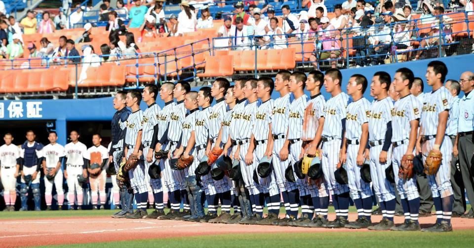 校歌斉唱をする東海大相模ナインとベンチ前に整列する日大藤沢ナイン（奥）