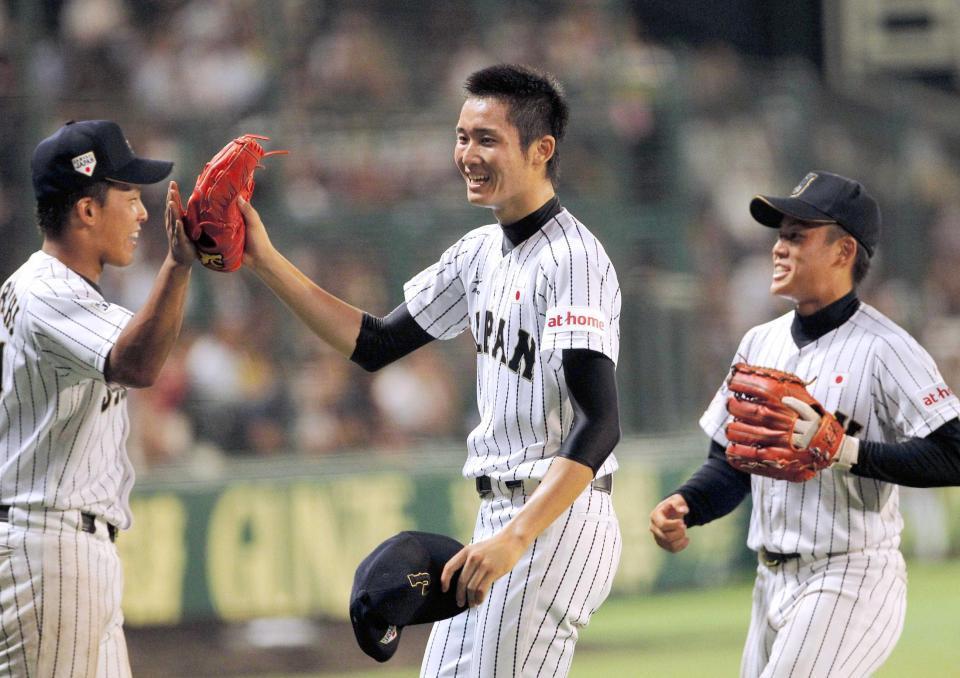 　９回、１イニングを無失点に抑え笑顔でナインとタッチを交わす高橋純（中央）＝撮影・保田叔久