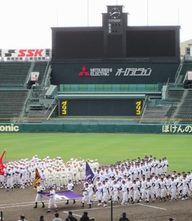 　甲子園球場で行進する、全国高校野球選手権大会の第１回大会に出場した各校のＯＢたち＝１９日午後、兵庫県西宮市