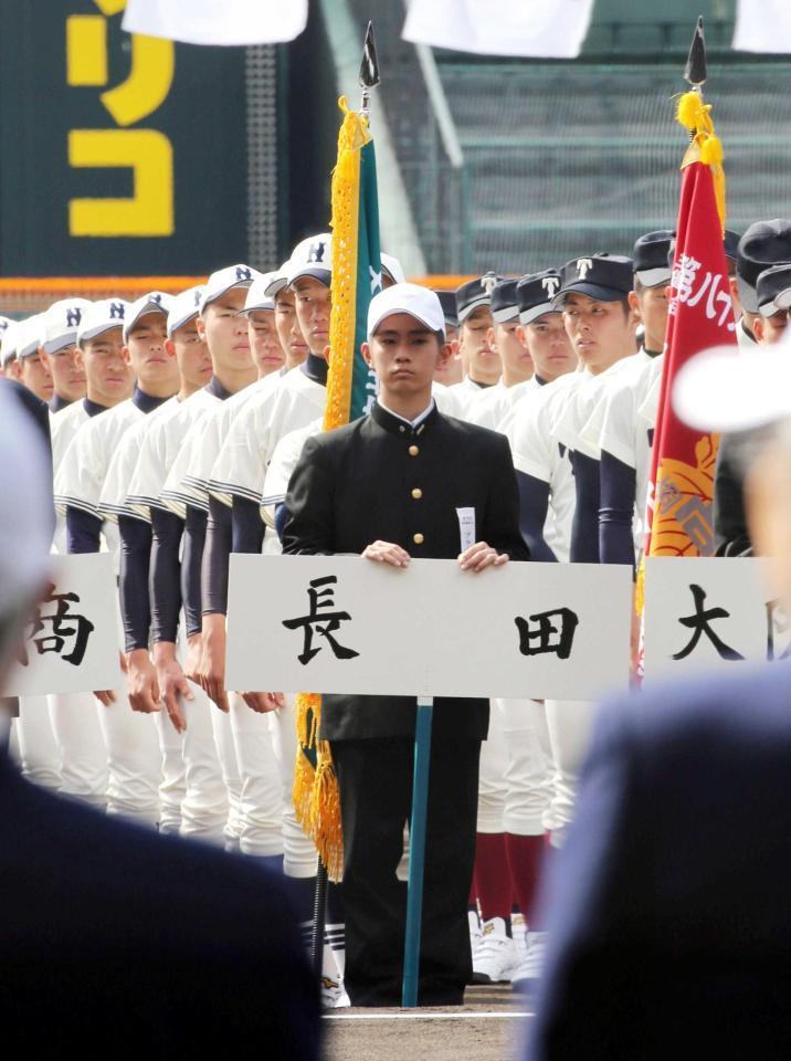 　開会式でプラカードを持つ長田・大堺コーチ兼スコアラー（撮影・山口登）