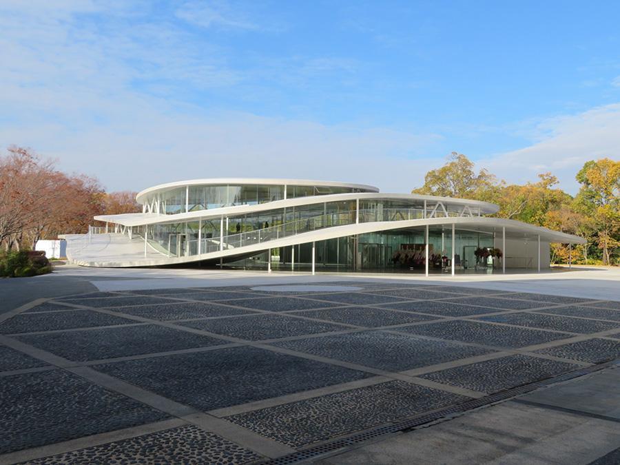 妹島和世設計による、大阪芸術大学アートサイエンス学科新校舎の外観。そびえ立つというよりも、丘の上にふんわりと着地した印象