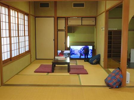 「飯川雄大個展」会場風景。一番奥の和室では過去作品の資料や映像が見られる。手前のチェックのカバンも作品