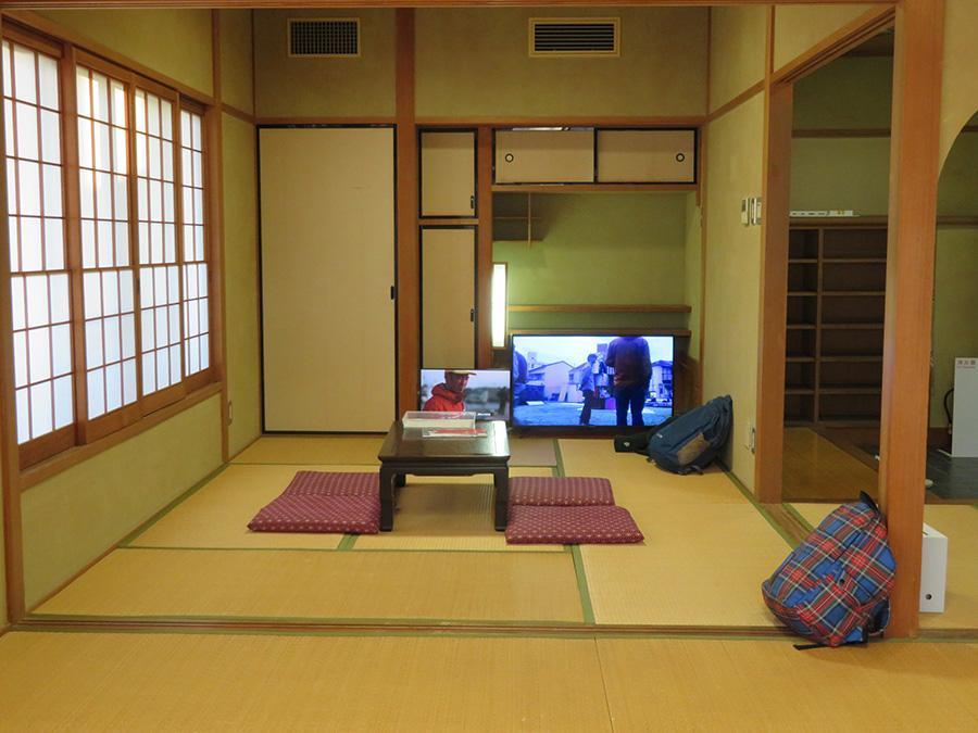 「飯川雄大個展」会場風景。一番奥の和室では過去作品の資料や映像が見られる。手前のチェックのカバンも作品