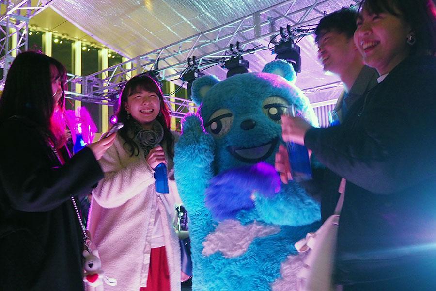 お立ち台に登場した同ビルの公式キャラクター「あべのべあ」と一緒にダンスする若者たち（７日・大阪市内）