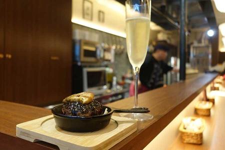 　７月４日に大阪難波駅ナカに登場した「小皿鉄板酒場 グリル千本」。トリュフソースのハンバーグ６８０円。ワインは４８０円均一