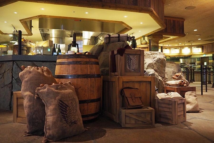 立体機動装置や調査兵団の遠征用鞄、衣類などが無造作に置かれた『進撃の巨人 調査兵団の食堂』内