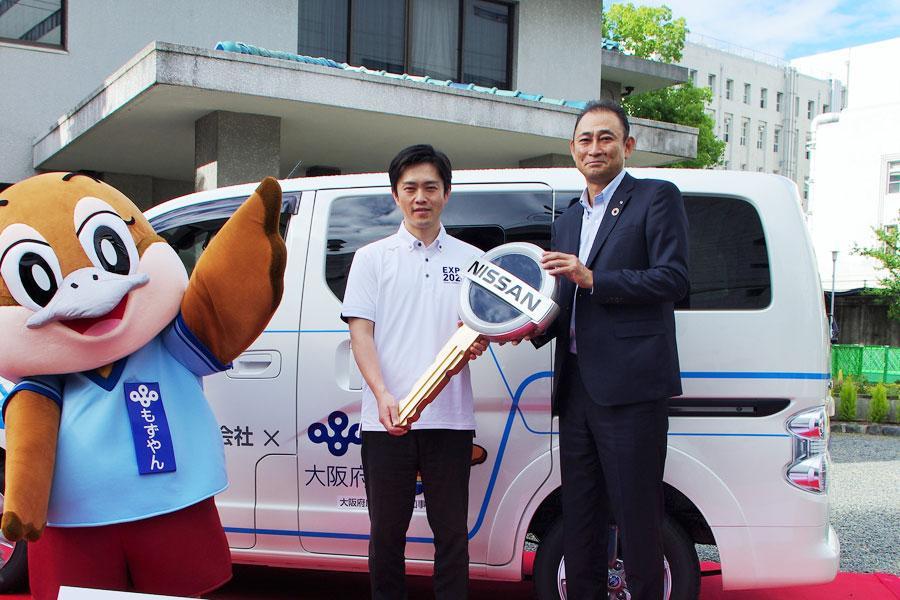 寄贈したＥＶ車両の前に立つ日産大阪販売の白土貴久社長（右）と吉村洋文大阪府知事（６月１０日・大阪府庁）