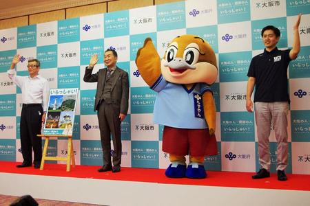 　『大阪の人・関西の人　いらっしゃい！』セレモニーで「いらっしゃーい」を披露する３人と１羽。左からと松井一郎市長、桂文枝、もずやん、吉村洋文知事（６月１６日・大阪市）