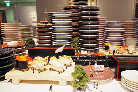 大阪駅や梅田の高層ビル群に見立てた風景を、寿司の汽車が走る動く作品も登場