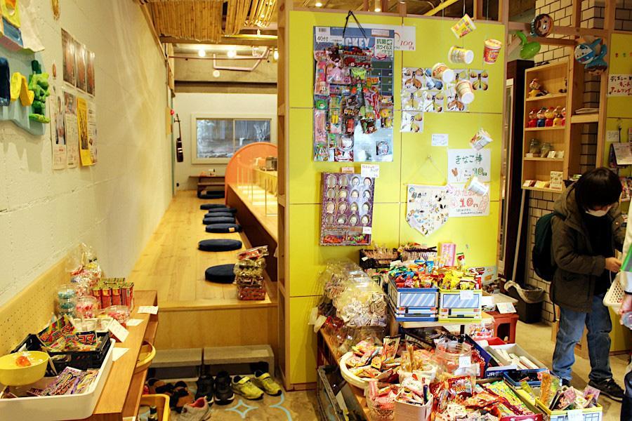 店内の様子。手前が駄菓子屋、カウンター席では飲食が可能。一番奥が「たまり場」でお金が無くても利用できる