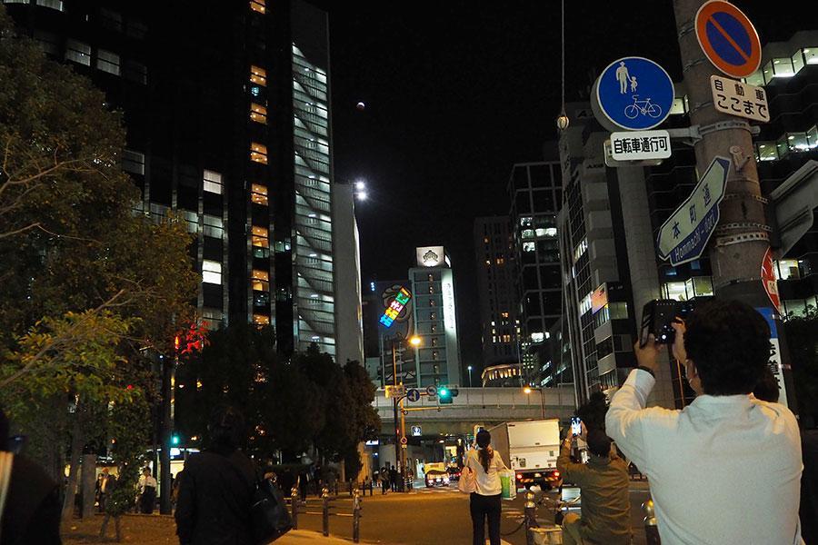 「皆既月食＋惑星食」を撮影する人々（8日、大阪市内）