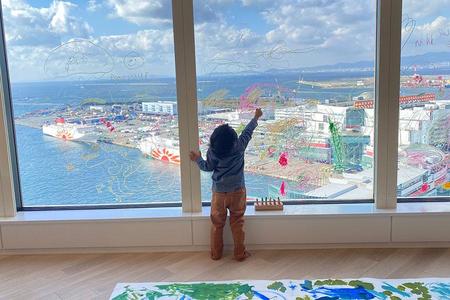 　大阪湾を望む最上階のガラス窓に自由に画を描く子ども