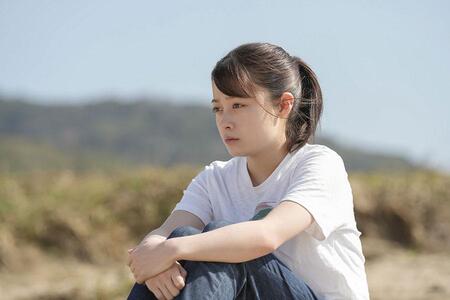 　『おむすび』第２１回より、海辺でたたずむ結（橋本環奈）（Ｃ）ＮＨＫ