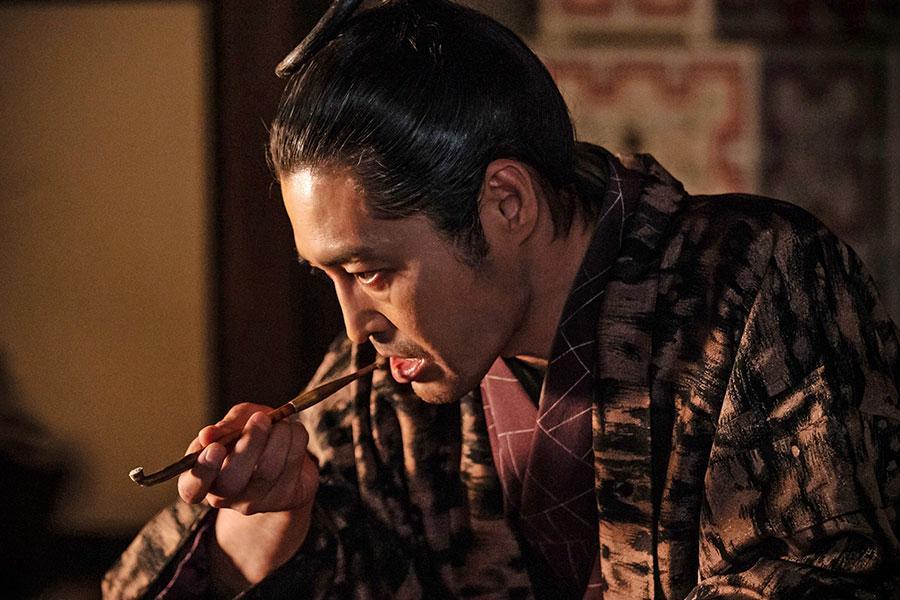 　『べらぼう～蔦重栄華乃夢噺～』第１６回より。煙草をキセルで吸う平賀源内（安田顕）（Ｃ）ＮＨＫ