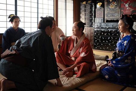 　『べらぼう～蔦重栄華乃夢噺～』第１８回より。「居続け」の間に病にかかり、医師の診察を受ける朋誠堂喜三二（写真中央、尾美としのり）（Ｃ）ＮＨＫ