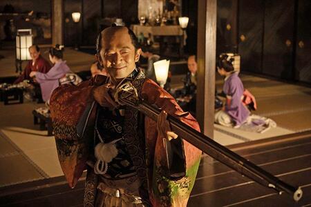 『べらぼう～蔦重栄華乃夢噺～』第２１回より。宴席で人に火縄銃を向ける遊びに興じる、松前藩主・松前道廣（えなりかずき）（Ｃ）ＮＨＫ