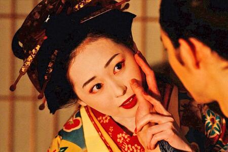 『べらぼう～蔦重栄華乃夢噺～』第２２回より。田沼意知（宮沢氷魚）の手を自身の頬に添える花魁・誰袖（福原遥）（Ｃ）ＮＨＫ