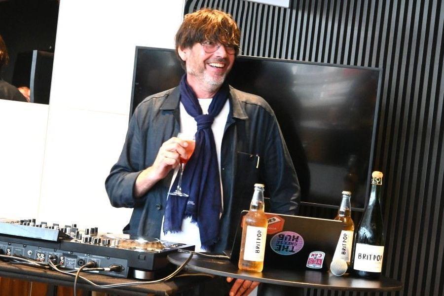 　自身がつくるワイン「ブリットポップ」片手にＤＪ、アレックス・ジェームス（６月１４日／大阪・関西万博　撮影：Ｌｍａｇａ.ｊｐ編集部）