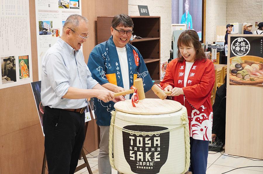 　オープニングセレモニーの鏡開きの様子。左から高知県大阪事務所所長・辻和生さん、土佐のおきゃく大使・植野広生さん、日本酒バー女将・森裕子さん（６月１８日・阪神梅田本店）