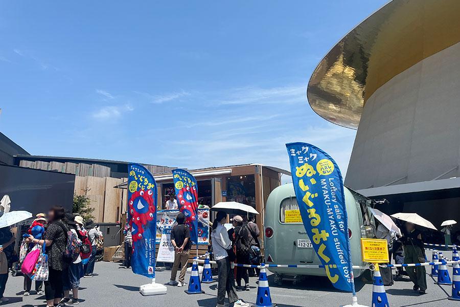 　『２０２５大阪・関西万博』６月１９日・シャインハット前のミャクミャクぬいぐるみくじ売り場。行列は大屋根リングまで続き、１２時時点で２時間待ちに（Ｌｍａｇａ.ｊｐ撮影）