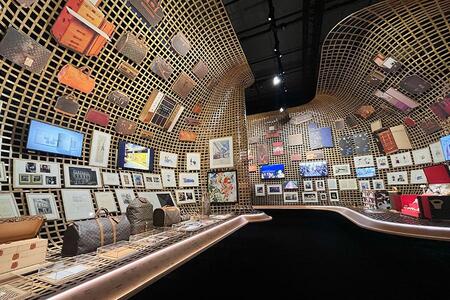 　歴代のトランクやバッグなどが壁いっぱいに並ぶ（『ビジョナリー・ジャーニー』より、Ｌｍａｇａ.ｊｐ撮影）