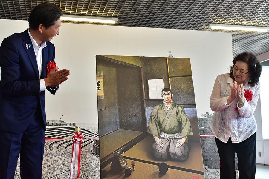 　左から永藤英機堺市長、さいとう・プロダクション代表取締役社長の齊藤輝子氏。中央は今回から展示される『ゴルゴ１３』と堺市のコラボレーション作品（９月１２日・大阪府堺市）