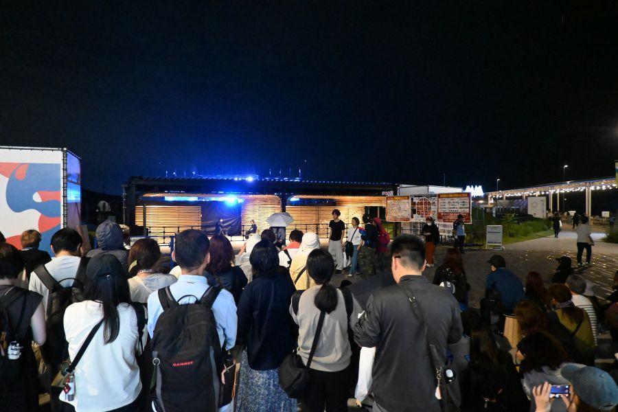 　大阪・関西万博「和歌山ＤＡＹ」ＨＹＤＥスペシャルライヴの会場外でライブの様子をうかがう人たち（１０月３日／Ｌｍａｇａ.ｊｐ撮影）