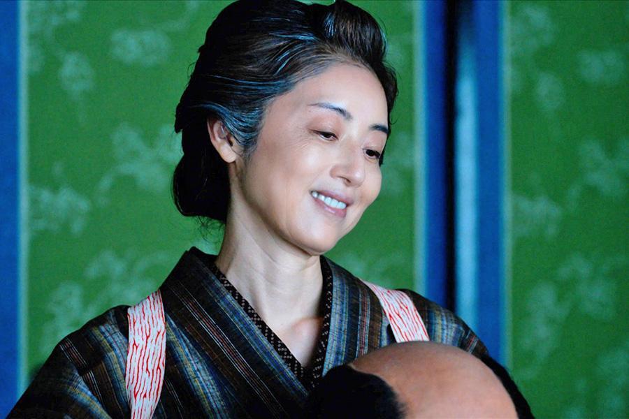 　『べらぼう～蔦重栄華乃夢噺～』第４１回より。髷を結いながら、重三郎の生い立ちについて話す母・つよ（高岡早紀）　©ＮＨＫ
