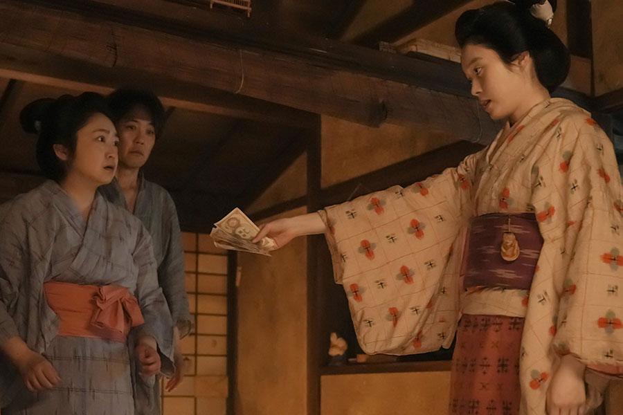 　『ばけばけ』第３３回より。借金取りに大金を払うトキ（写真右、高石あかり）と、大金に驚く母・フミ（写真左、池脇千鶴）たち　©ＮＨＫ