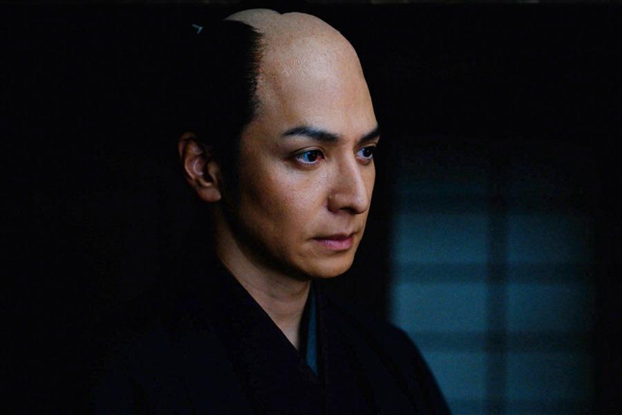 　『べらぼう～蔦重栄華乃夢噺～』第４６回より。松平定信たちが潜む浄瑠璃小屋に現れた、一橋治済（生田斗真）似の男　©ＮＨＫ