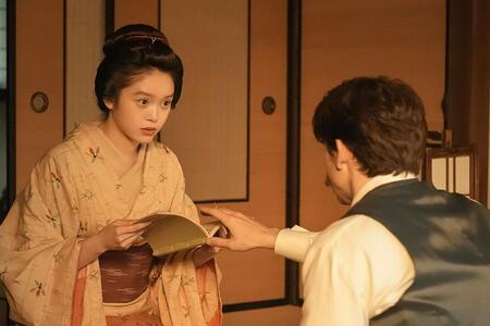 　『ばけばけ』第５７回より。『本邦諸国奇談集』を手に取るトキ（高石あかり）を制するヘブン（トミー･バストウ）©ＮＨＫ