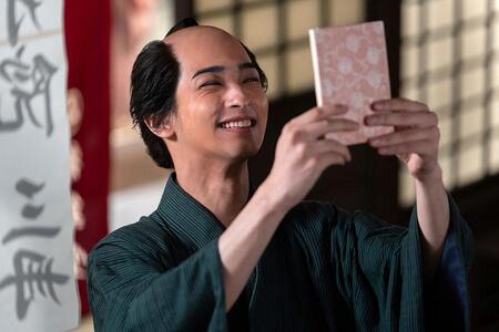 　『べらぼう～蔦重栄華乃夢噺～』第２回より。完成した『吉原細見』を手に満面の笑みを浮かべる蔦屋重三郎（横浜流星）©ＮＨＫ