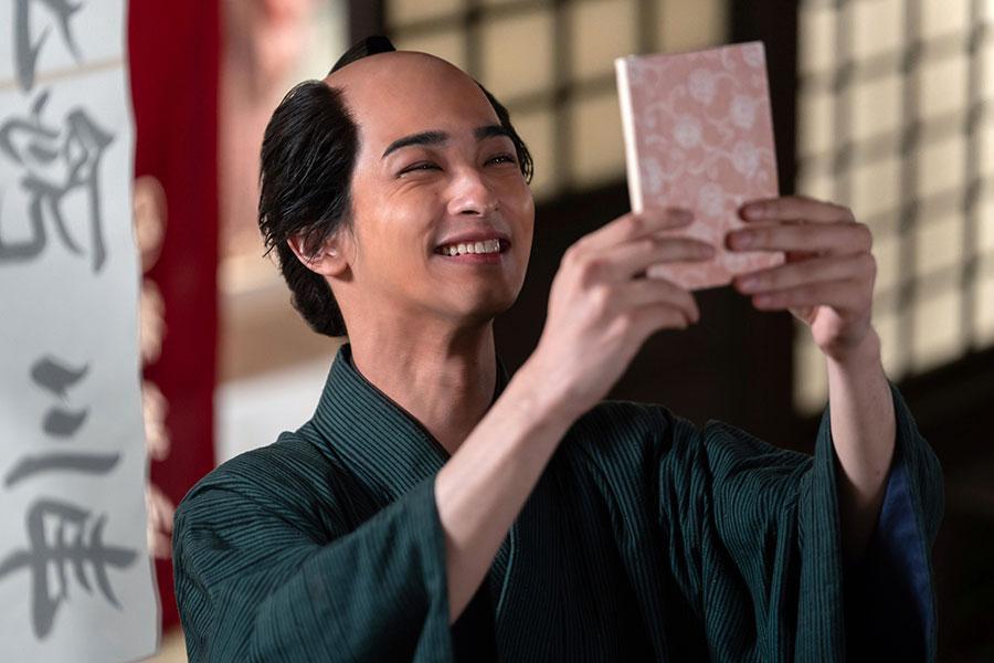 　『べらぼう～蔦重栄華乃夢噺～』第２回より。完成した『吉原細見』を手に満面の笑みを浮かべる蔦屋重三郎（横浜流星）©ＮＨＫ