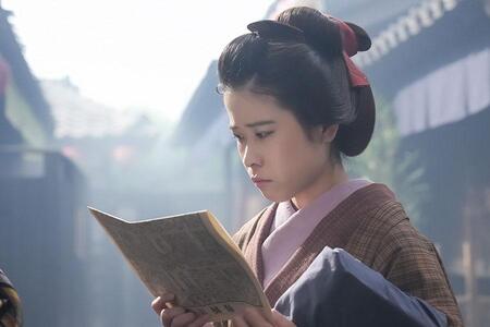 『ばけばけ』第77回より。「ヘブン先生日録」が掲載された新聞を読むトキの幼馴染み・サワ（円井わん）（C）NHK