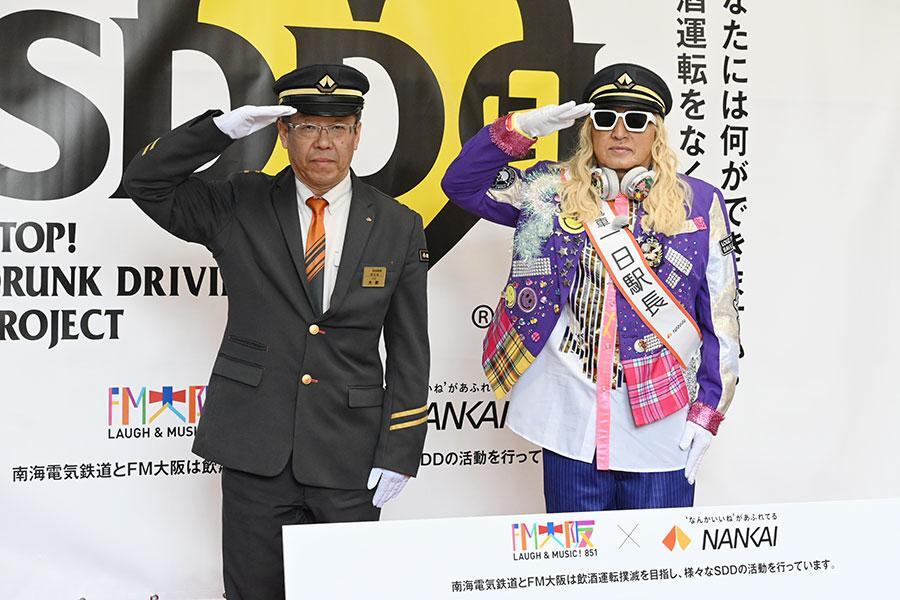南海なんば駅の1日駅長として敬礼ポーズをするDJ KOO、大家駅長（2月14日・大阪市内）