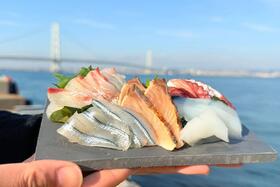 　看板メニューの「淡路島産お刺身盛り合わせ」３２４０円（画像提供：岩屋鮮魚／背景：明石海峡大橋）